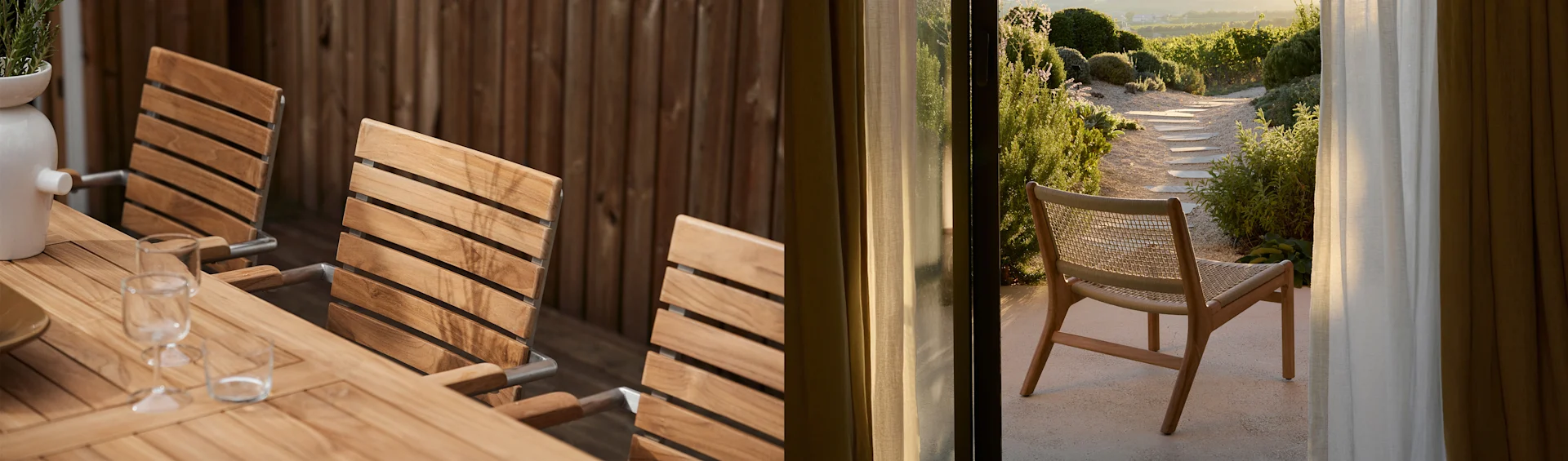 Patio esterno con tavolo e sedie in legno, accanto a una porta a vetri aperta che rivela un sentiero e vigneti.